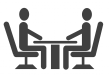 Teiknuð mynd af tveimur einstaklingum sem funda við borð