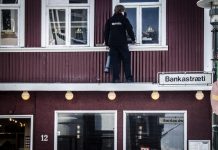 Verkamaður þrífur glugga í bankastræti