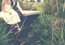 Brúðkaupsafmæli Brúðarhjón sitja á viðarbrú í sveitinni