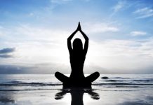 Hugleiðsla, einfaldar leiðir til að byrja að hugleiða. Kona situr í jógastöðu við hafið