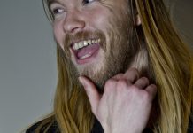 Síðhærður skeggjaður maður skellir upp úr